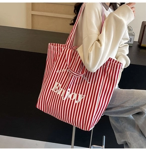 Detailed close-up of the red and white striped canvas tote bag featuring Enjoy print