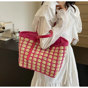 Détail du sac cabas en paille tissée rose à carreaux tenu par un mannequin en dentelle