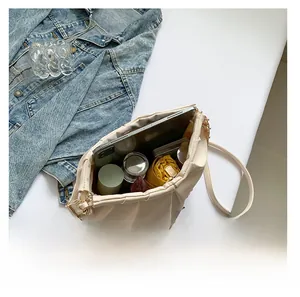Top view detail of large capacity cream PU leather shoulder bag showing daily essentials