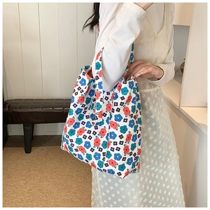 Detail of floral printed canvas tote bag featuring red and blue patterns on white fabric