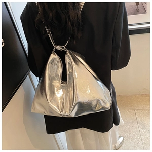 Close-up of metallic silver PU shoulder bag with geometric triangle pleated texture