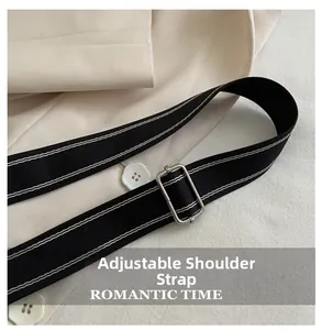 Detail of adjustable black canvas shoulder strap with white stitching and silver metal buckle