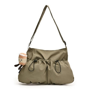 Olive green nylon crossbody bag with drawstring pockets and plush coffee cup charm