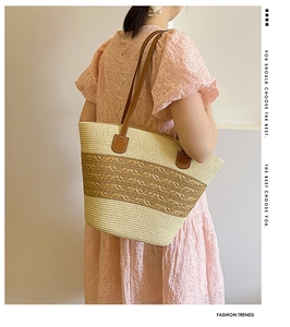 Detail of woven straw tote bag with brown leather handles and dual-tone beige texture