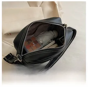 Internal capacity of the black PU crossbody bag with white stitching and interior pocket