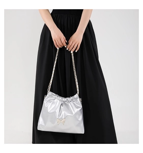 Detail view of silver PU crossbody bag with butterfly metal ornament and chain strap