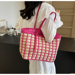 Détail du sac cabas en paille tissé main avec bandoulière rose et coutures contrastées