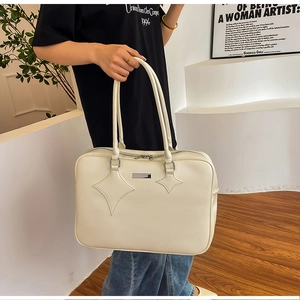 Close-up of cream white PU leather tote bag with star quilted details and metal plate