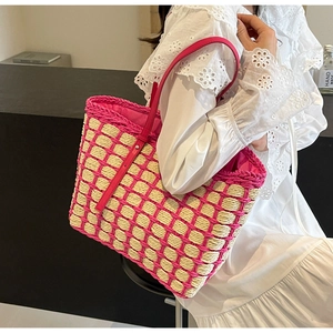 Détail du sac cabas en paille à carreaux roses porté avec une robe en dentelle