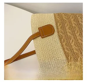 Detail view of woven fabric and leather trim with neat stitching on a beige shoulder bag