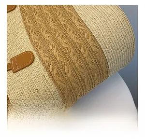Macro detail of beige woven fabric with brown leather trim and contrast stitching on tote bag