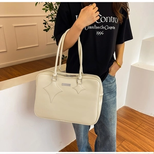 Detail of off-white PU leather tote bag with star stitching and rectangular metal plaque