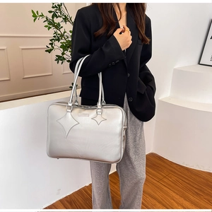 Detail of silver metallic tote bag with star stitching and high-quality PU texture finish