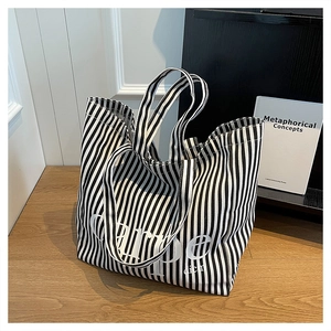 Fashionable black and white vertical striped canvas tote bag with Carpe Diem lettering