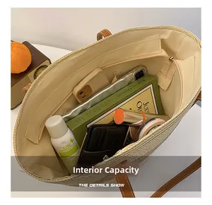 Interior view showing the large capacity of the beige woven straw tote bag with brown leather handles