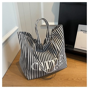 Minimalist canvas tote bag with black and white vertical stripes and carpe print design