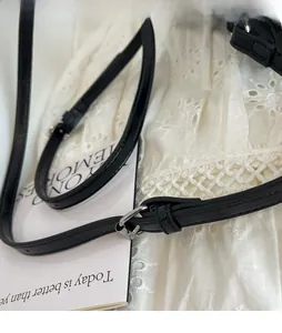 Detail of adjustable black faux crocodile skin shoulder strap with silver buckle