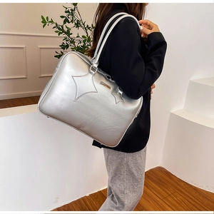 Close-up of metallic silver PU leather tote bag with star stitching and long shoulder straps