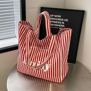 Fashionable red and white striped canvas tote bag featuring Enjoy New York City typography