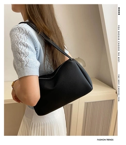 Side view of black pebbled leather hobo bag worn by model in casual outfit