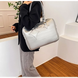 Model wearing a large silver matte PU leather tote bag with star stitched details