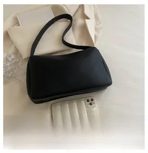 Close-up of black lychee grain PU leather shoulder bag with sleek minimalist texture