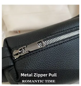 Close-up of high-quality silver metal zipper pull on black litchi pattern PU leather bag