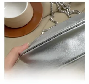 Détails de couture de précision sur un sac à bandoulière matelassé argenté