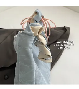 Detail view of light blue textured PU bag with ruffle edge and smooth handmade stitching