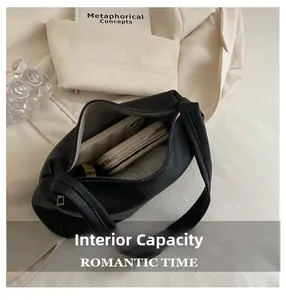 Spacious interior of black pebble leather shoulder bag with zipper and inner compartment