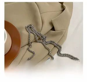 Détail d'un sac argenté matelassé avec bandoulière en chaîne et coutures en losange