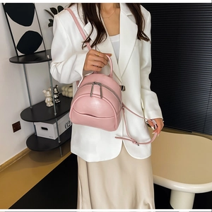 Detail shot of mini pink PU leather backpack with silver zippers and adjustable straps