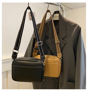 Detail view of leather camera bags with striped wide straps in black and khaki colors