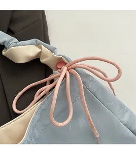 Close-up of PU leather shoulder bag featuring unique pink drawstring and round buckle detail