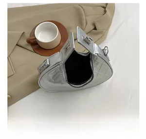 Vue de dessus d'un sac demi-lune argenté matelassé montrant l'espace intérieur zippé