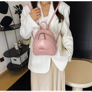 Close-up of pink PU leather mini backpack showing smooth texture and silver metal zippers