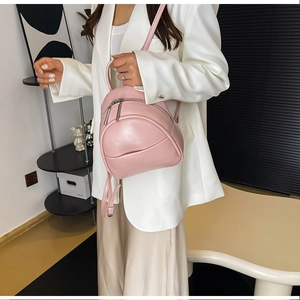Detail view of a pink PU leather mini backpack with double zipper and front pocket
