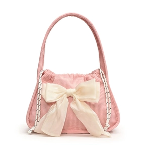 Pink corduroy handbag featuring a large cream silk bow and decorative side drawstrings