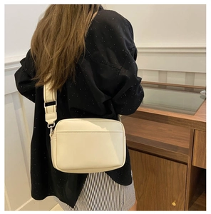 Model view showing the minimalist cream PU leather crossbody bag with wide shoulder strap