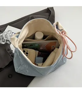 Detail showing spacious interior of the blue PU drawstring bag with iPad and accessories