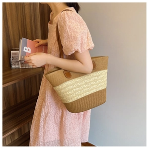 Detail of handwoven tote bag with striped color blocks and premium brown leather handles