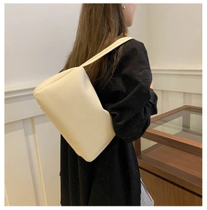 Detail of minimalist cream PU leather shoulder bag featuring a classic lychee grain texture
