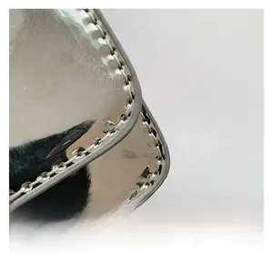 Macro shot of silver mirrored PU leather bag showing detailed stitching and edge craftsmanship