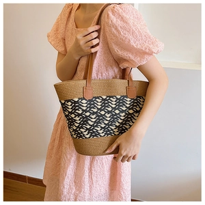 Detailed close-up of woven tote bag showing brown leather handles and geometric textures