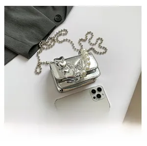 Detail of silver PU bag with 3D heart, butterfly, pearl handle and metal ball chain
