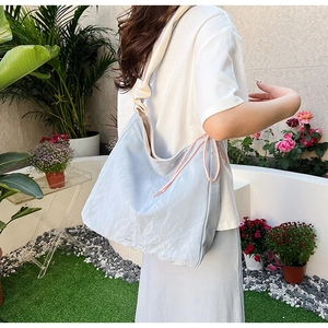Detail of light blue PU leather tote bag featuring stylish pink drawstring and texture