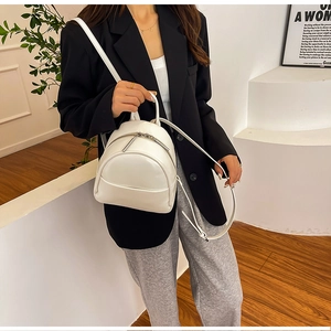 Detailed view of a white PU leather mini backpack with silver zippers and adjustable straps