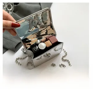Detail view of mini silver metallic bag interior showing capacity for small cosmetics