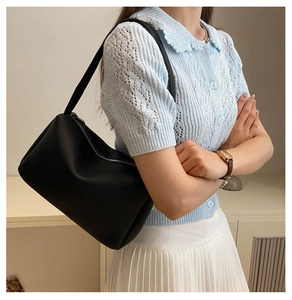 Detailed view of black pebbled PU leather hobo bag styled on a female model's shoulder