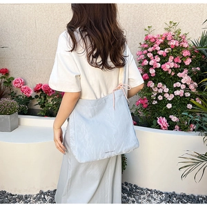 Detailed back view of a light blue PU tote bag featuring a Fashion & Bags printed text logo
